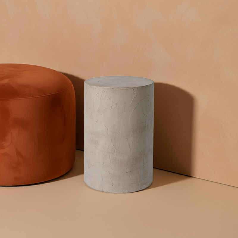 Noční stolek z mikrobetonu a měkký taburet v moderním interiéru, s minimalistickým designem. Stolky ideální pro elegantní a funkční doplnění každého prostoru.