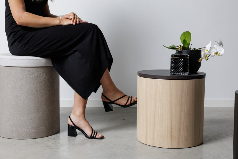 Designový odkládací stolek z dubového dřeva s tmavou deskou a kulatý taburet z mikrobetonu, moderní minimalistický nábytek do obýváku