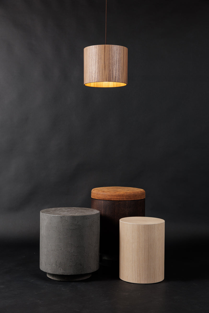 Noční stolky z mikrobetonu a dřeva v různých odstínech, se zavěšeným osvětlením v pozadí. Moderní a elegantní design pro každý interiér.