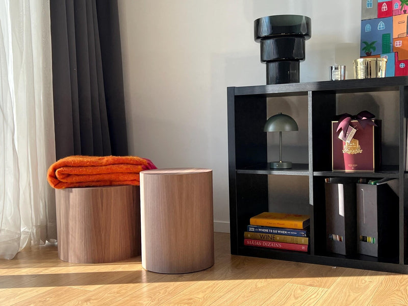 Noční stolky z dřeva, jeden z nich s přehnutým dekorem a oranžovou dekou. Moderní a funkční design pro útulné interiéry.